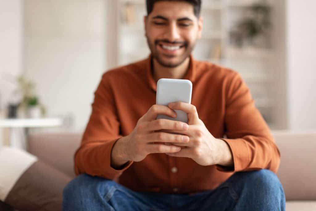 Man smiling playing games on Android smartphone